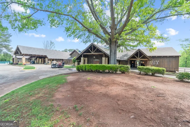 a front view of a house with a yard and trees