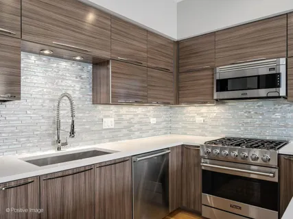 a kitchen with stainless steel appliances a stove sink and microwave