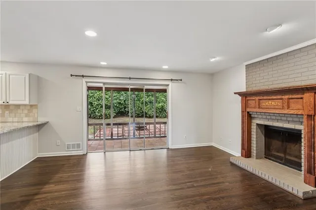 a view of an empty room with a fireplace and a window