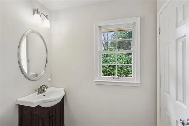 a bathroom with a sink mirror and a window