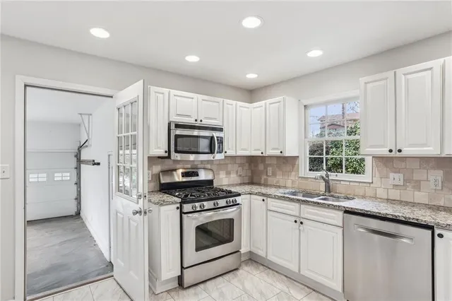 a kitchen with white cabinets and white appliances