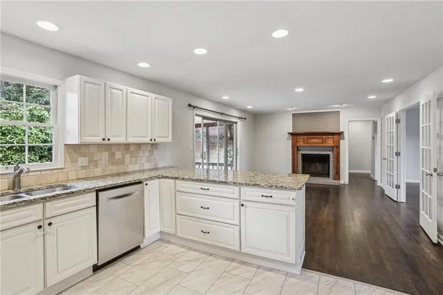 a kitchen with white cabinets and sink