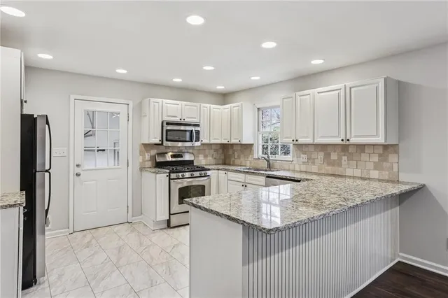 a kitchen with kitchen island granite countertop a stove sink and refrigerator