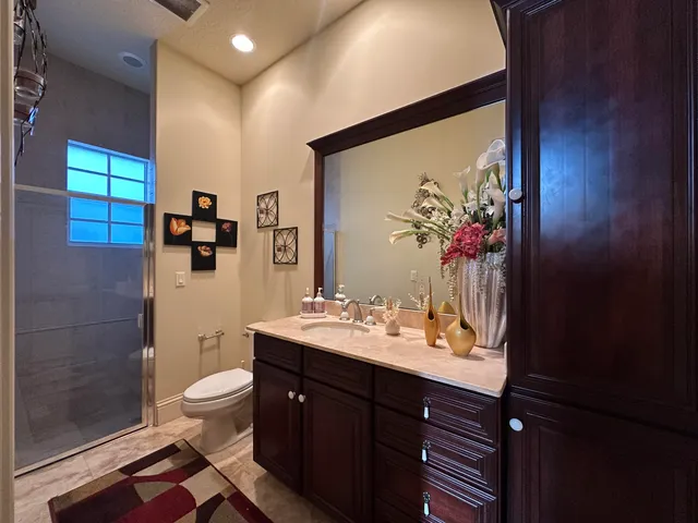 a bathroom with a double vanity sink toilet and mirror