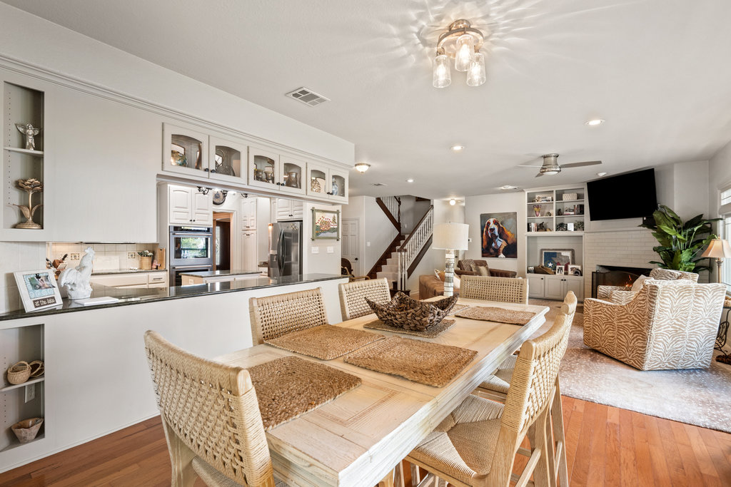 104 River Ranch Road Kingsland, TX 78639 - Photo 13 of 39 Dining space with stairway, light wood finished floors, built in shelves, a lit fireplace, and recessed lighting