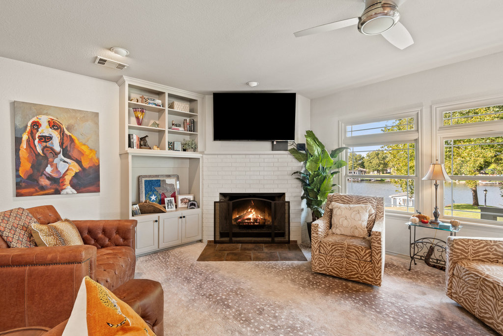 104 River Ranch Road Kingsland, TX 78639 - Photo 17 of 39 Living area featuring a brick fireplace, a ceiling fan, and built in features