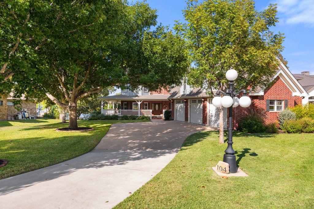 104 River Ranch Road Kingsland, TX 78639 - Photo 2 of 39 View of front of property with brick siding, concrete driveway, a front yard, and an attached garage