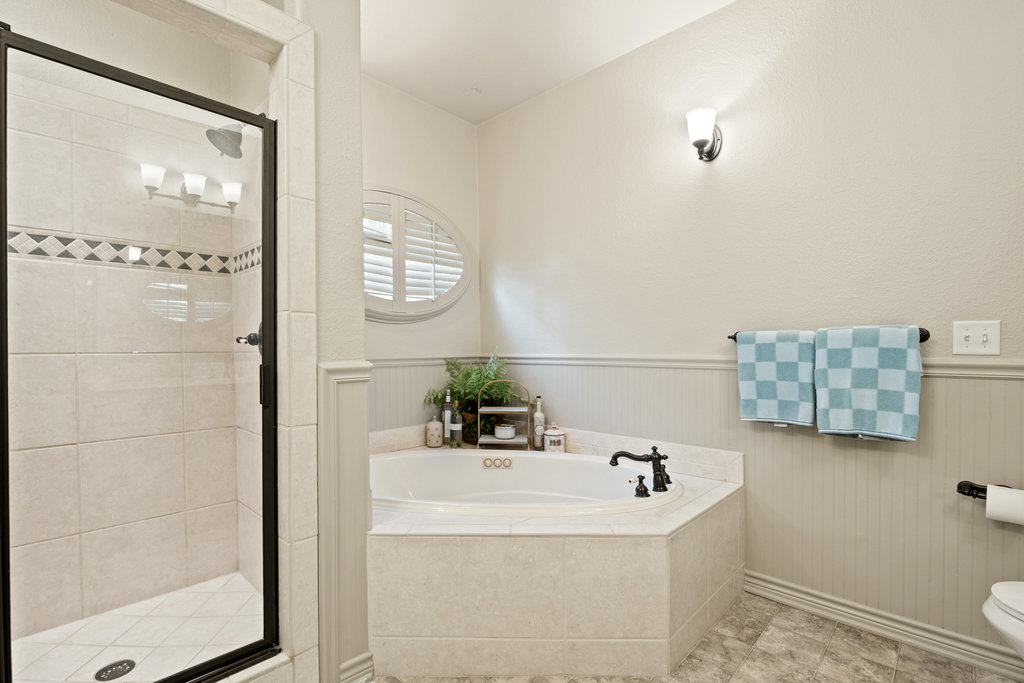 104 River Ranch Road Kingsland, TX 78639 - Photo 23 of 39 Full bathroom with wainscoting, a garden tub, and a stall shower