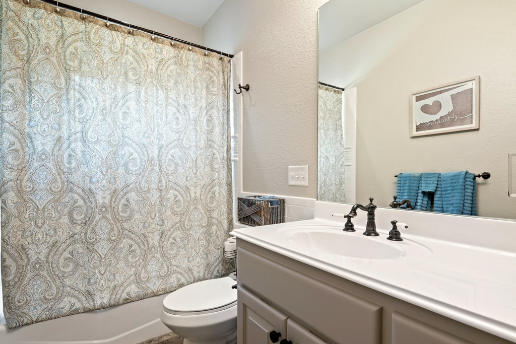 104 River Ranch Road Kingsland, TX 78639 - Photo 27 of 39 Bathroom with a textured wall, vanity, and shower / bath combo with shower curtain