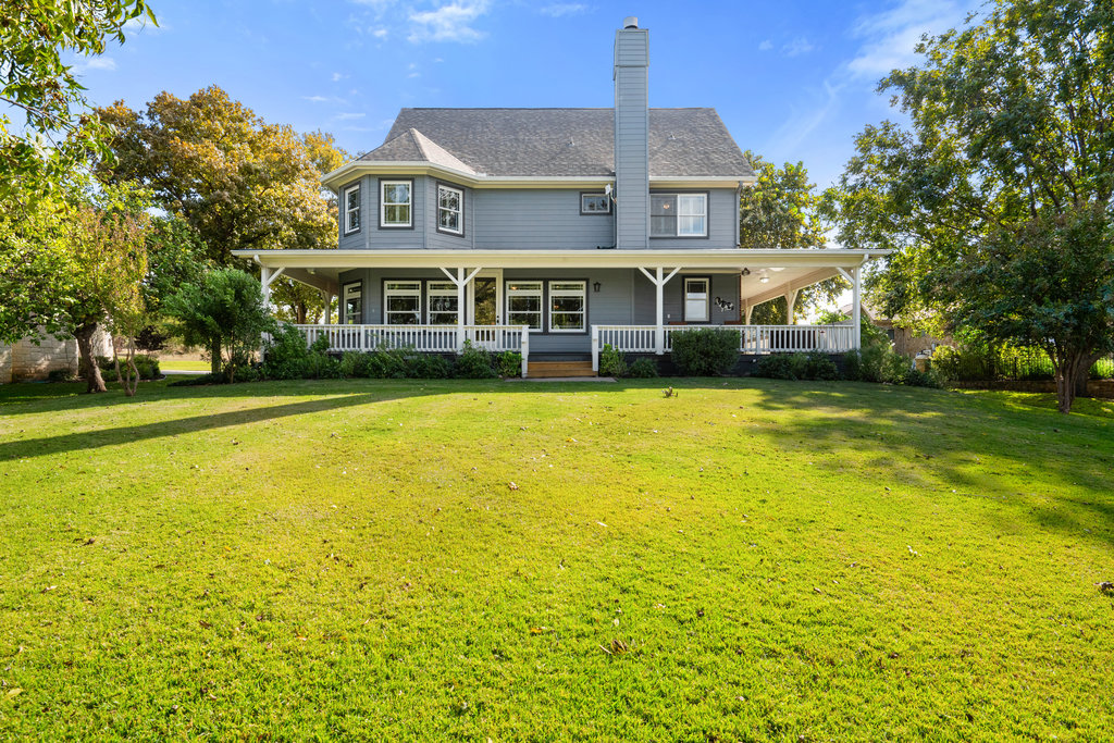 104 River Ranch Road Kingsland, TX 78639 - Photo 30 of 39 Back of property featuring a porch, a chimney, a lawn, and roof with shingles