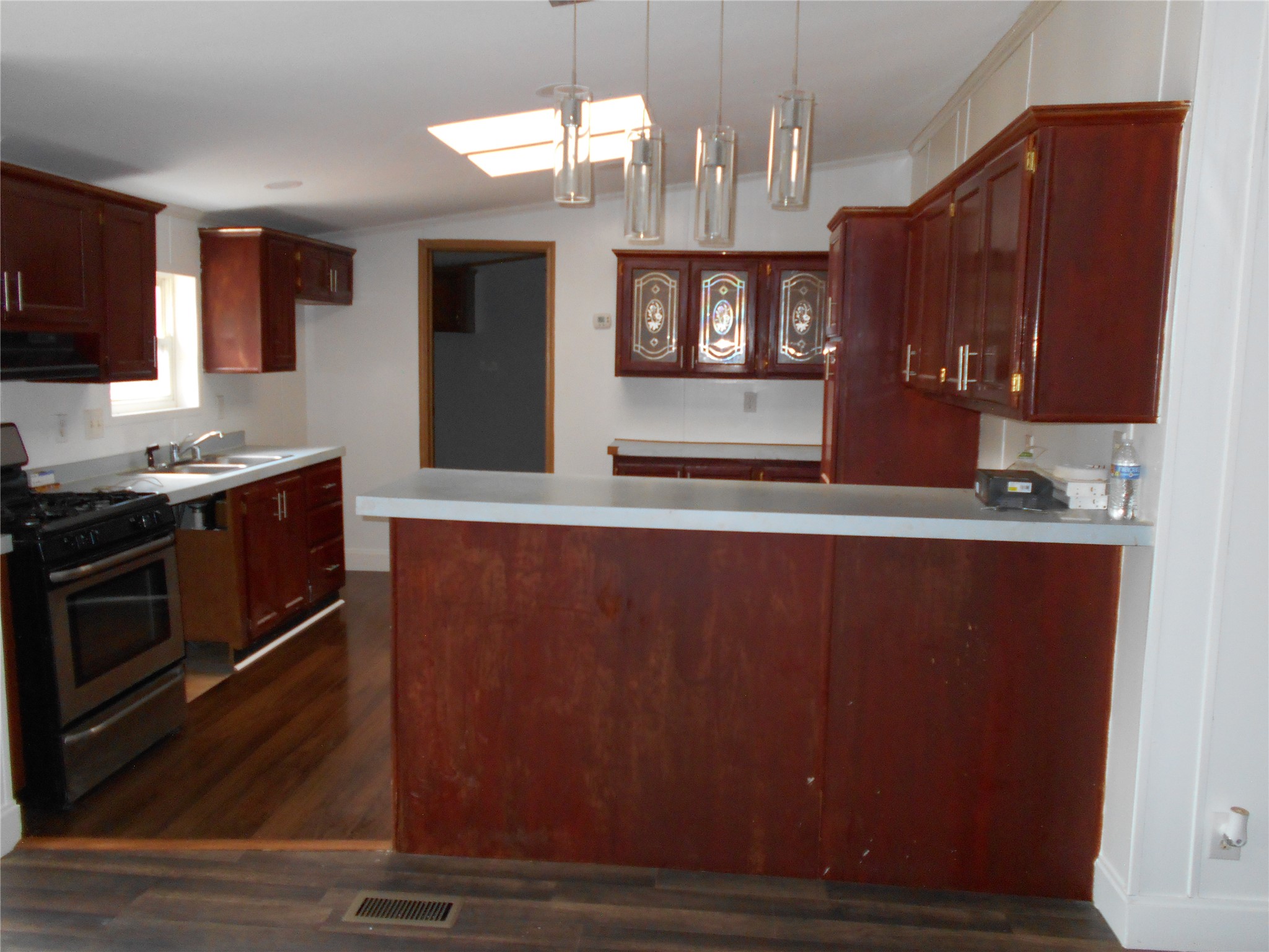8001 Burleson Manor Road Manor, TX 78653 - Photo 13 of 31 A skylight brightens this kitchen with warm wood cabinetry and a functional island.