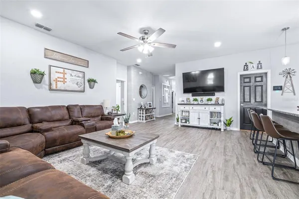 a kitchen with stainless steel appliances kitchen island granite countertop a dining table chairs and white cabinets