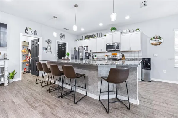 a kitchen with kitchen island cabinets and chairs in it