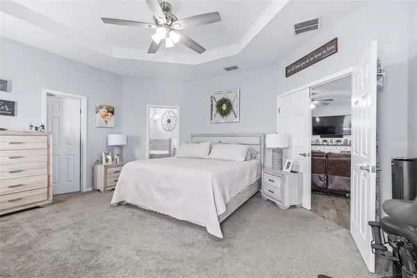 a bedroom with a bed a flat screen tv and dresser