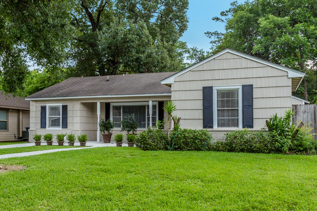 a view of a house with backyard garden and plants