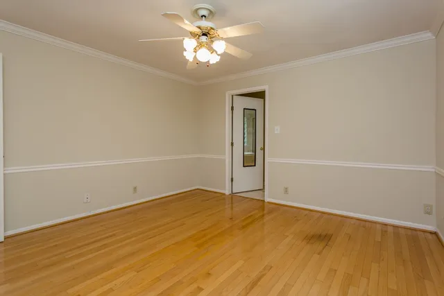 an empty room with a windows and ceiling fan