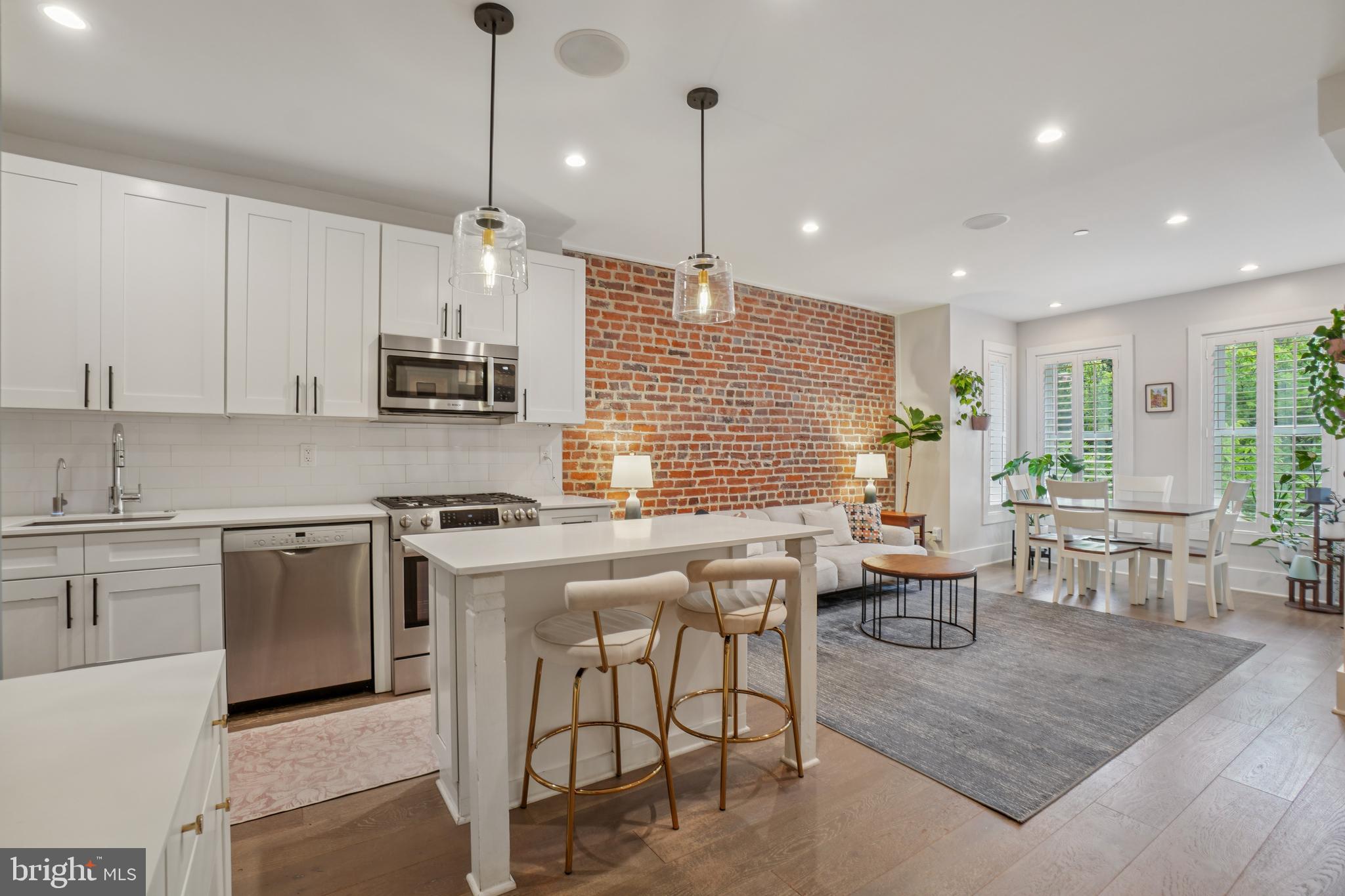 1682 Irving Street Northwest, Unit 2 Washington, DC 20010 - Photo 5 of 25 a kitchen with stainless steel appliances granite countertop a stove top oven a sink dishwasher a dining table and chairs with wooden floor