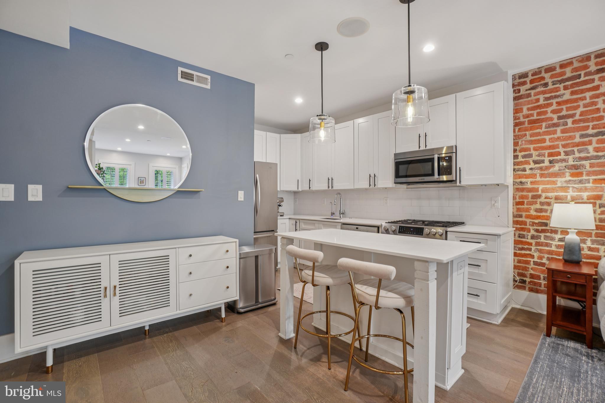 1682 Irving Street Northwest, Unit 2 Washington, DC 20010 - Photo 7 of 25 a kitchen with stainless steel appliances granite countertop a stove a sink dishwasher a refrigerator white cabinets and wooden floor