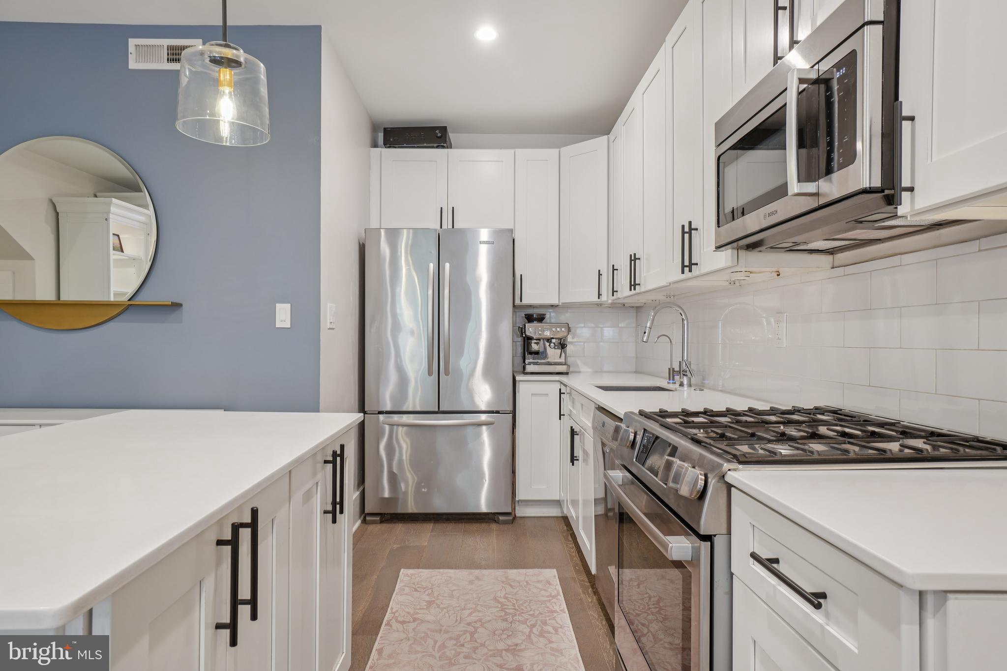 1682 Irving Street Northwest, Unit 2 Washington, DC 20010 - Photo 8 of 25 a kitchen with stainless steel appliances granite countertop a refrigerator a stove and a sink with wooden floor