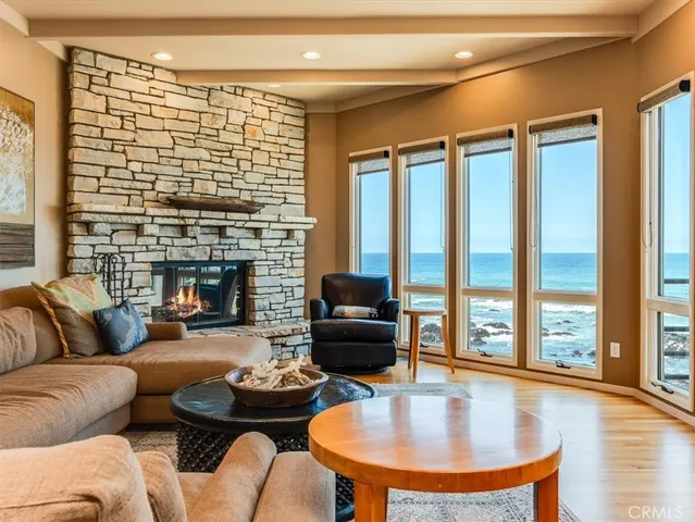 a living room with fireplace furniture and a large window