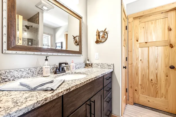 a bathroom with a granite countertop sink and a mirror