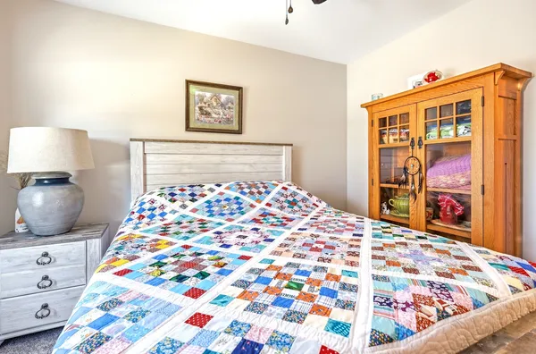 a bedroom with a bed and a lamp on dresser