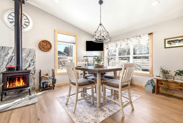 a view of a dining room and livingroom with furniture wooden floor a chandelier