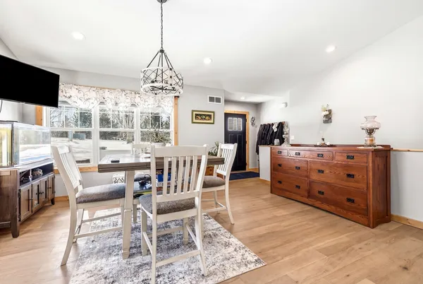 a dining room with furniture window and wooden floor