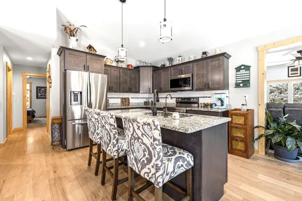a kitchen with stainless steel appliances granite countertop a sink a stove and a refrigerator