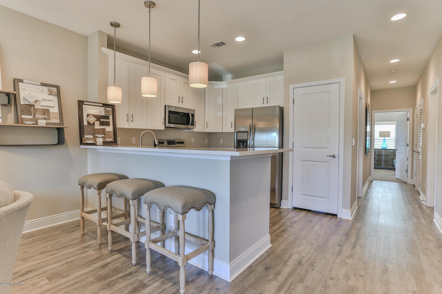 22958 Ann Miller Road Panama City Beach, FL 32413 - Photo 18 of 29 a kitchen with stainless steel appliances a dining table chairs refrigerator and microwave