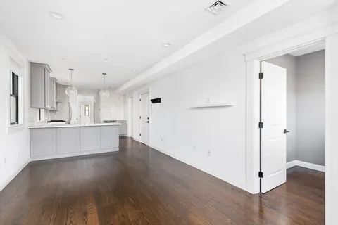 a view of a kitchen with wooden floor and electronic appliances