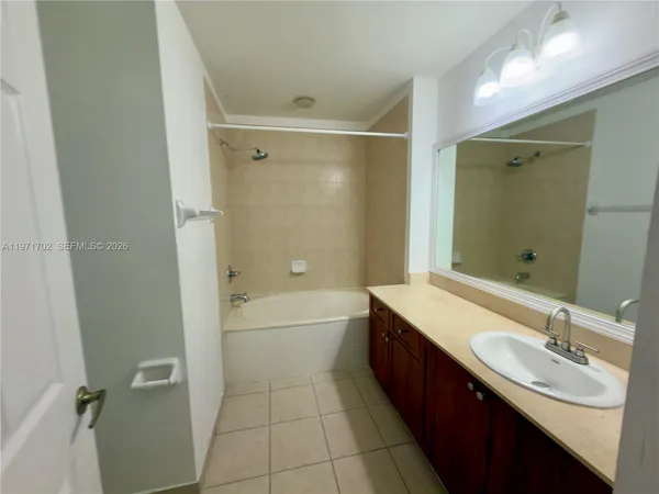 a bathroom with a tub sink shower and mirror