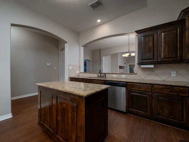 a kitchen with cabinets and wooden floor