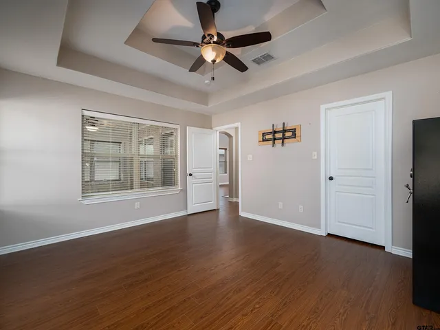 a view of an empty room with window and wooden floor