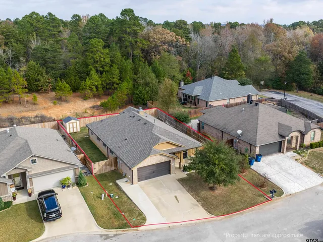an aerial view of a house with trees in the background
