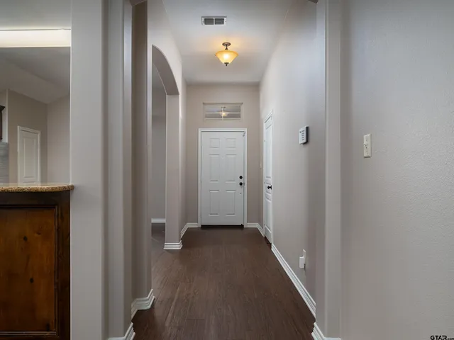 a view of a hallway with wooden floor