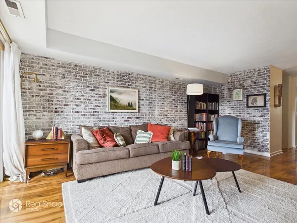 a living room with fireplace furniture and wooden floor
