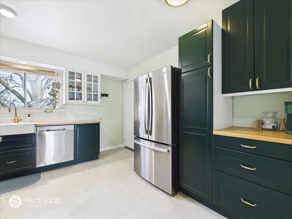 a kitchen with stainless steel appliances granite countertop a refrigerator and a stove top oven