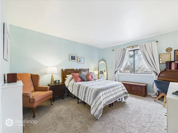 a bedroom with a bed couch and window