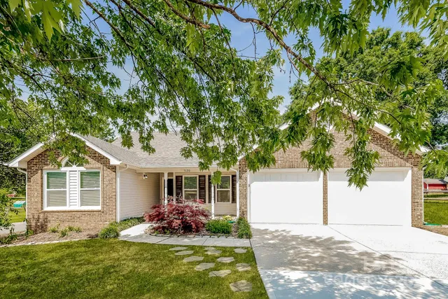 a front view of a house with a garden and yard