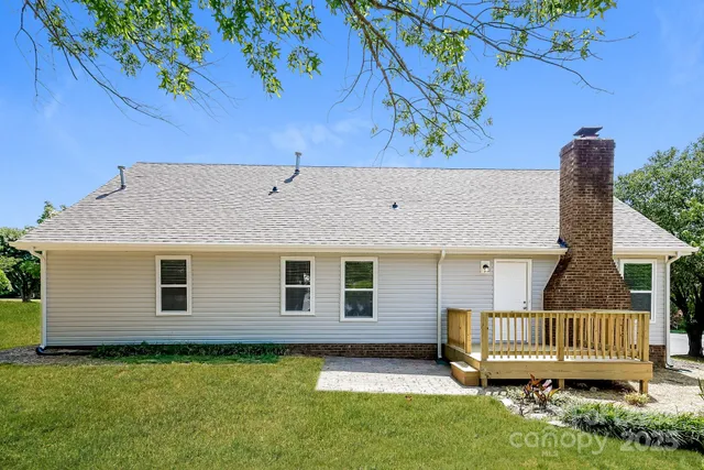 a view of a house with a yard and deck