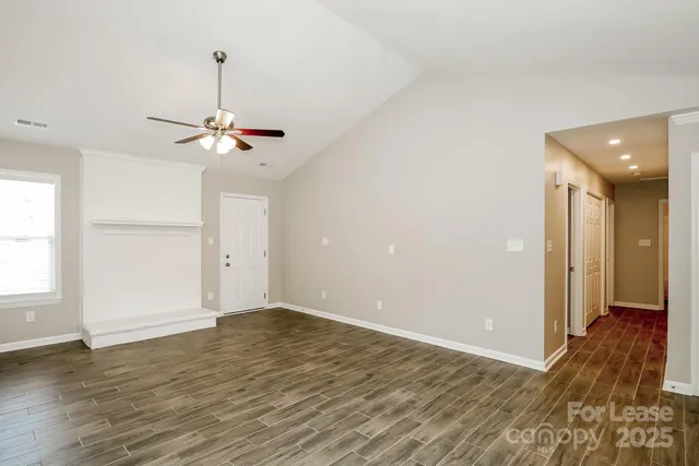 a view of empty room with wooden floor and ceiling fan