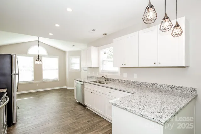 a kitchen with granite countertop a sink a stove and cabinets