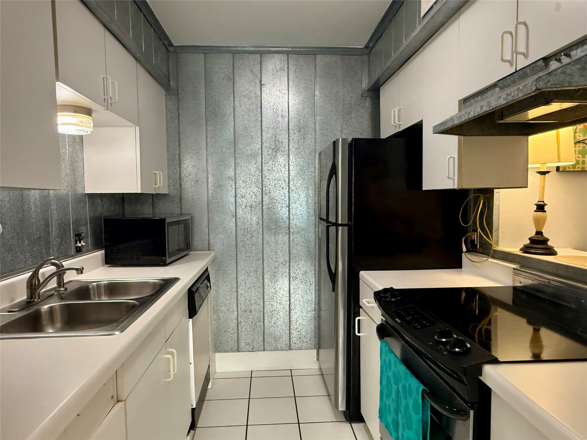 500 East Riverside Drive, Unit 149 Austin, TX 78704 - Photo 4 of 26 Galley kitchen features light cabinetry, clean white countertops, and distinctive metallic wall paneling.