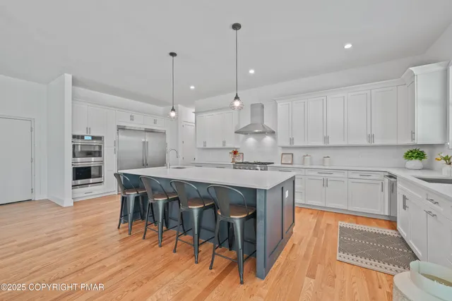 a kitchen with stainless steel appliances granite countertop a kitchen island a stove a table and chairs in it