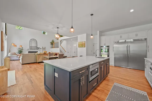 a kitchen with a stove a refrigerator a sink dishwasher with a dining table and chairs