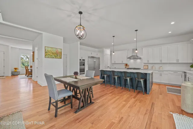 a dining room with kitchen island stainless steel appliances furniture a dining table and chairs