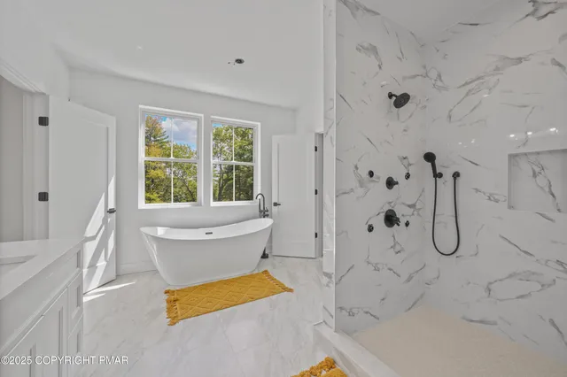 a bathroom with a tub sink and mirror
