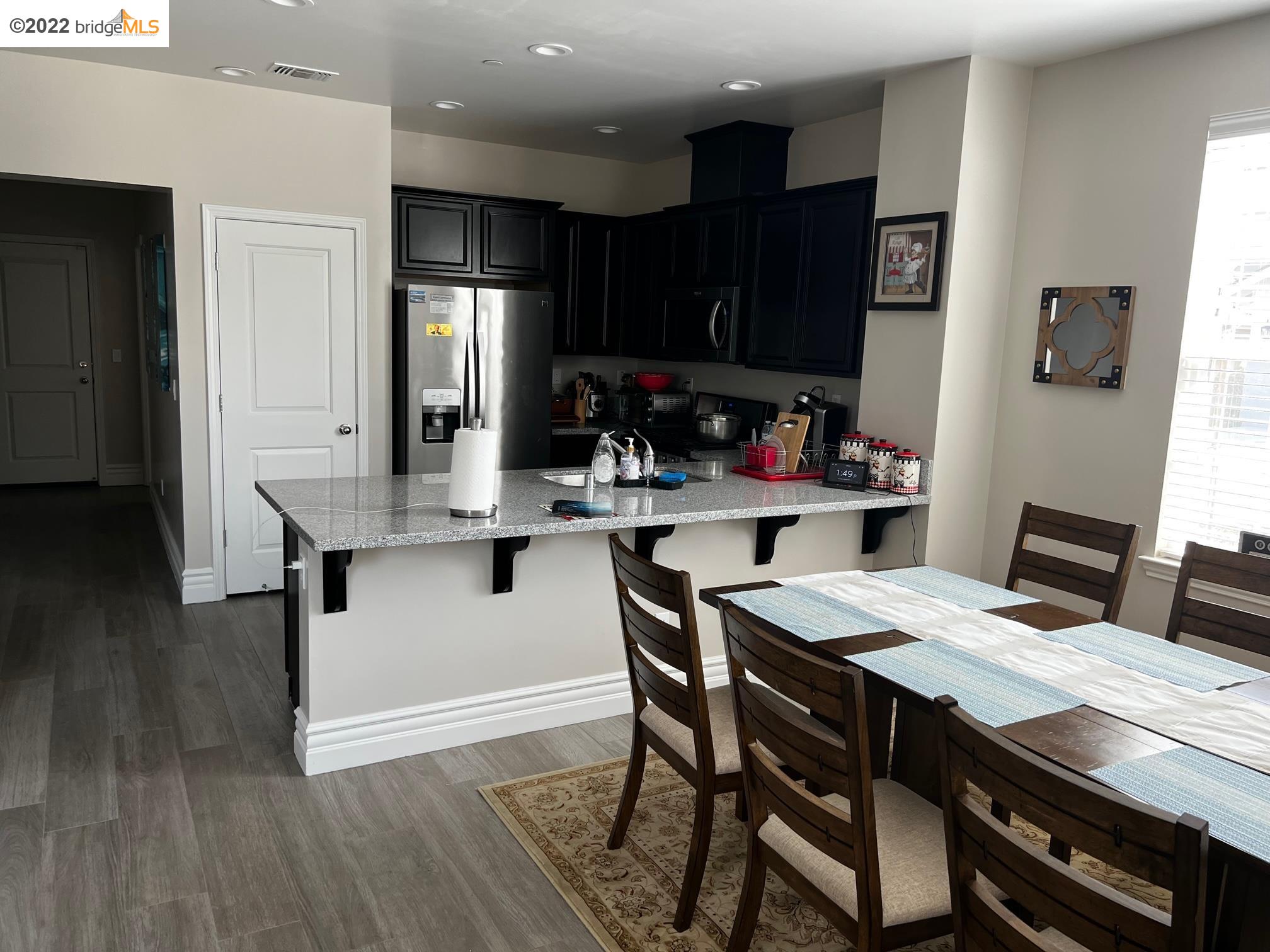 East Garrison Marina, CA 93933 - Photo 3 of 11 a kitchen with stainless steel appliances kitchen island granite countertop a table chairs and a refrigerator