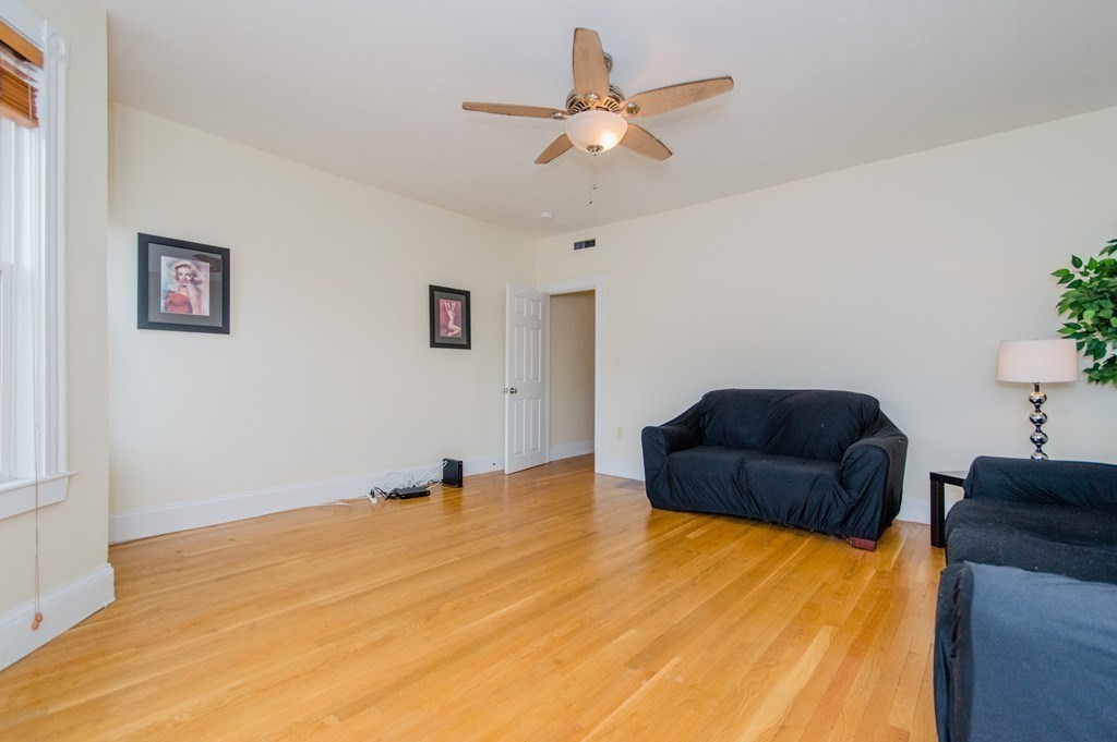 126 Minden Street, Unit 3 Boston, MA 02130 - Photo 5 of 12 a bedroom with a bed and a ceiling fan